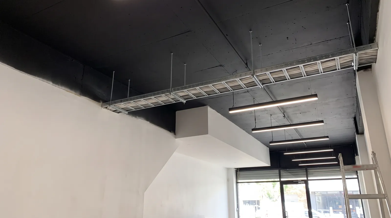 Cable tray and a line of LED strip lights in an empty shop fit-out