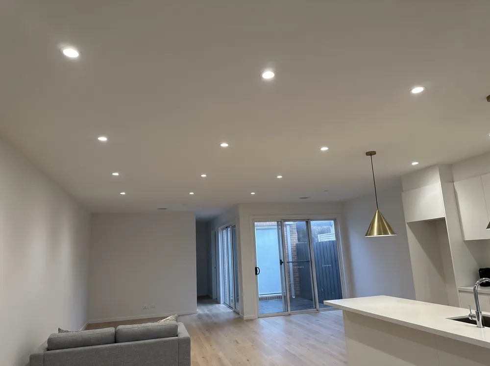 A downlight washing a wall above a shelf